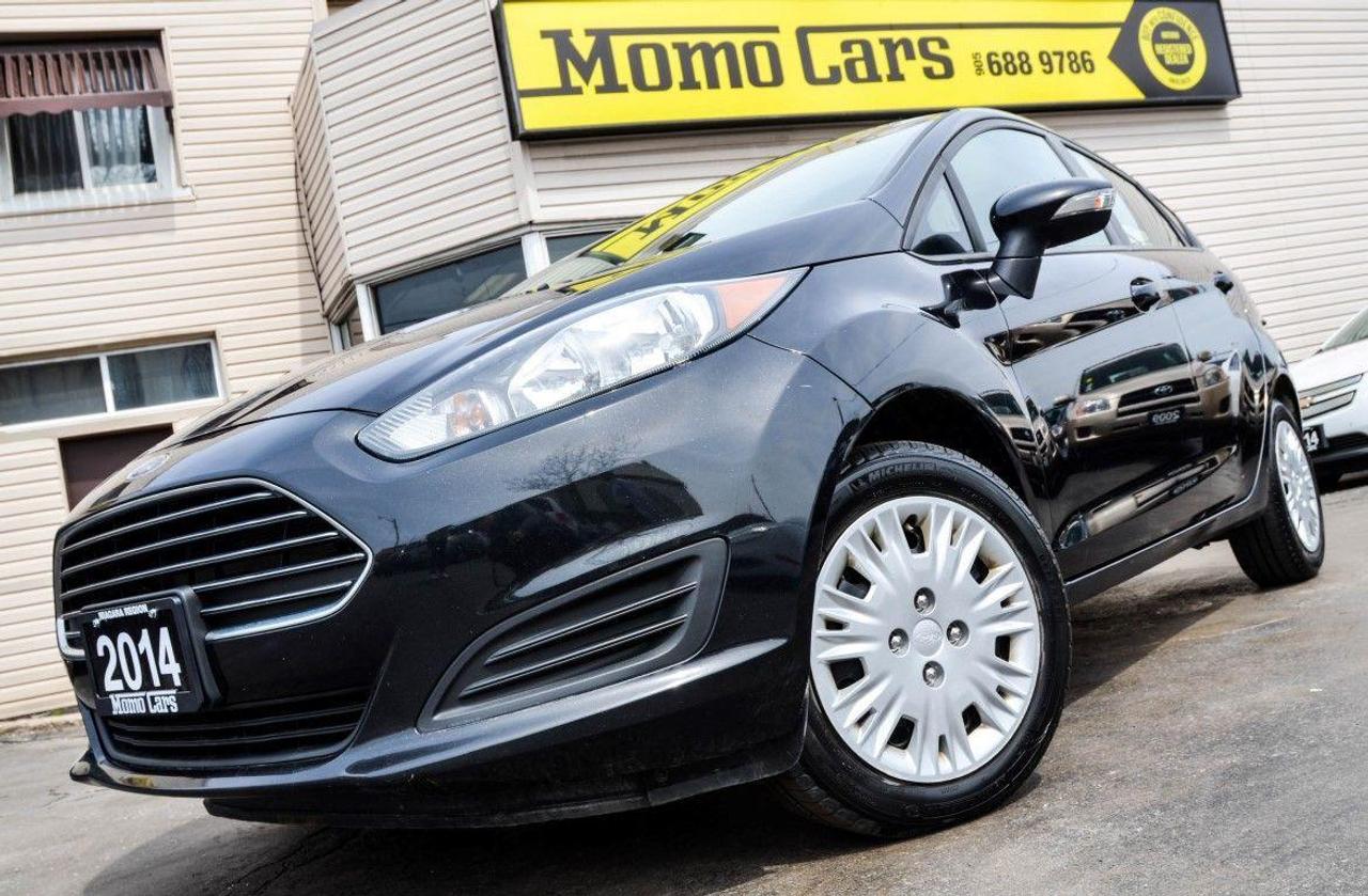 2014 Ford Fiesta Hatchback!  Microsoft Sync! Cruise! ONLY $93/bi-weekly!

4 Cylinder 1.6L Engine! + Cruise Control+ Bluetooth + USB/Auxiliary Inputs + Steering Wheel Controls + Microsoft SYNC + MyKey Technology and so much more!

Meet Natalie! The newest member of the Momo fleet! Boasting the title of best-selling subcompact across the globe, the Ford Fiesta is a fierce competitor in the small car market. Ford resurrected a legacy nameplate in the Blue Oval family with a sparkling new Fiesta hatchback that sports new technology inside and underneath. The result was a car that todays newly arrived urbanites should find perfectly fitted to their needs, wants and comforts. Inside, the Fiesta broke new ground in the mobile multimedia market with a voice activated infotainment system dubbed Microsoft SYNC. Non voice audio controls and for creature comfort settings revert to basic knobs and buttons that are sized and arrayed for ease of use with minimal distraction from driving. Comfortable seats have enough side and bottom bolsters to keep occupants properly positioned, but gingerly, without obstructing the passengers entry or exit. New MyKey technology allows owners (parents) to set maximum limits on vehicle speed and stereo volume, and prevents deactivation of safety systems. We promise Natalie will not disappoint! Call one of our Sales Professionals today and let?s get the conversation started!

Here are two awesome facts that you want to know:

1) Natalie includes Microsoft SYNC which is a factory-installed, integrated in-vehicle communications and entertainment system that allows users to make hands-free telephone calls, control music and perform other functions with the use of voice commands!

2) Not only is this car fun to drive, but it is SAFE TOO! Safety equipment standard on all Fiesta models includes seven airbags, including dual-stage frontal, front seat side impact, side curtain and driver knee; a post-crash alert system; antilock brakes and electronic stability control.
	
Did You Know? The very first Ford sold was to Dr. Pfennig in 1903, for a grand total of $850. The ?Model A? had a 2-cylinder engine, and could reach a max speed of 30 mph!

Finance Natalie Today! ONLY  Bi-Weekly! With $1000 down, 5 year loan @ 4.99%! (Sale Price: $9200 & Cost of borrowing $1402.87) For well-qualified buyers. Whether youve got perfect credit or blemished we can do it all at Momo Cars! Inquire further as to your specific situation! 
To fill out our online CREDIT APPLICATION please visit:
www.momocars.ca/financing

Financing available for any and every situation. LOW INCOME, BANKRUPTCY, COLLECTIONS AND EVEN O.D.S.P.! We can do it all! From amazing prime rates to subprime! Youll be amazed at the Momo Difference! Dont hesitate to get a risk-free pre-approval today! Vehicle Repossession? Low Income? Student? Newly arrived to Canada? We can do it all! Down Payment May Be Required!

Call ahead to one of our experienced Sales Professionals as this one won?t last long!

Call: 905-688-9786
Email: info@momocars.ca
Text: 289-407-2838

Momo Cars Inc
www.MomoCars.ca

Located in Downtown St Catharines. We are a trusted member of the UCDA and licensed by OMVIC. Buy with confidence!

35 Minute Drive from Hamilton & Burlington. 60 Minute Drive from Toronto & Mississauga.