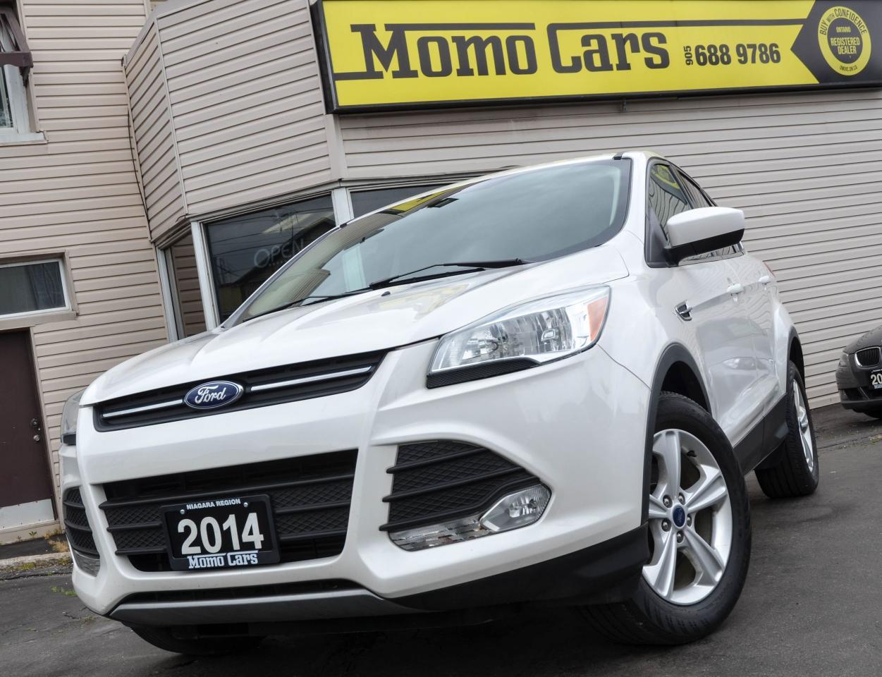 2014 Ford Escape SE!

Inline 4 Cylinder 2.5L Engine!Clean Carproof+  Backup Camera +Heated Seats+ Cruise Control + Air Conditioning + Bluetooth + Steering Wheel Controls + Keyless Entry + Voice Recognition + Microsoft SYNC + USB/Auxiliary Inputs and so much more! 

Meet Heather! The newest addition to the Momo Family! A total redesign of the Ford Escape for 2013 moved the top-selling compact SUV into the contemporary era, courtesy of high-tech small engines, a smooth 6-speed transmission, aerodynamic front styling, and electronic wizardry. Ford claimed 11 features exclusive to the Escape in the compact SUV class: everything from a capless fuel nozzle to Torque Vectoring Control, which helps the Escape corner more securely. A four-way manual passenger seat is standard in all 2014 Escape models; so is a rearview camera. Creature comfort is impeccable, even with the standard fabric upholstery, rugged and handsome. Interior materials are soft, and the plastic high quality. Rear legroom is decent, at 36.8 inches, and rear climate control is standard. Theres excellent cargo space, 68.1 cubic feet behind the first row and 34.3 cubic feet behind the second row, and the standard 60/40 rear seat folds flat wonderfully fast, using one lever. Overall, Escapes styling emulates its big brother, the Explorer. However, its nose more resembles its little sister, the Focus hatchback, distinctive, sort of aero stubby, with the familiar blue oval emblem centered in its wide, narrow grille. The hood has nice character lines, and the headlights sweep sharply back and up into muscular wheel wells. You won?t want to miss your chance to take home this beautiful ride! Call one of our Sales Professionals and let?s get the conversation started!

Here are two awesome facts that you want to know:

1) Heather includes Microsoft SYNC which is a factory-installed, integrated in-vehicle communications and entertainment system that allows users to make hands-free telephone calls, control music and perform other functions with the use of voice commands!

2) Safety equipment standard on all models includes AdvanceTrac traction and stability control with roll stability control, Curve Control, Torque Vectoring Control, two-stage frontal airbags, driver knee airbag, side airbags, ABS with Brake Assist, tire pressure monitor, and rear-view camera.

Fuel Economy: You can drive 50km for approx. $3.52! Rated at 7.84L/100km. Toronto from Niagara for $7.90! (Dependent on gas prices)

Did You Know? Henry Ford and Thomas Edison were lifelong friends. As requested by Ford, Thomas Edison?s son captured Edison?s last exhale in a test tube and sealed it with a cork. Ford kept the tube as a memorial to Edison?s ?life and breath.?

Finance Heather Today! ONLY $127.58 Bi-Weekly! With $1,000 down, 6 year loan @ 4.99%! (Sale Price: $14,888 & Cost of borrowing $2,707.31) For well-qualified buyers. Whether youve got perfect credit or blemished we can do it all at Momo Cars! Inquire further as to your specific situation! 

To fill out our online CREDIT APPLICATION please visit:
www.momocars.ca/financing

Financing available for any and every situation. LOW INCOME, BANKRUPTCY, COLLECTIONS AND EVEN O.D.S.P.! We can do it all! From amazing prime rates to subprime! Youll be amazed at the Momo Difference! Dont hesitate to get a risk-free pre-approval today! Vehicle Repossession? Low Income? Student? Newly arrived to Canada? We can do it all! Down Payment May Be Required!

Call ahead to one of our experienced Sales Professionals as this one won?t last long!

Call: 905-688-9786
Email: info@momocars.ca
Text: 289-407-2838

Momo Cars Inc
www.MomoCars.ca

Located in Downtown St Catharines. We are a trusted member of the UCDA and licensed by OMVIC. Buy with confidence!

35 Minute Drive from Hamilton & Burlington. 60 Minute Drive from Toronto & Mississauga.