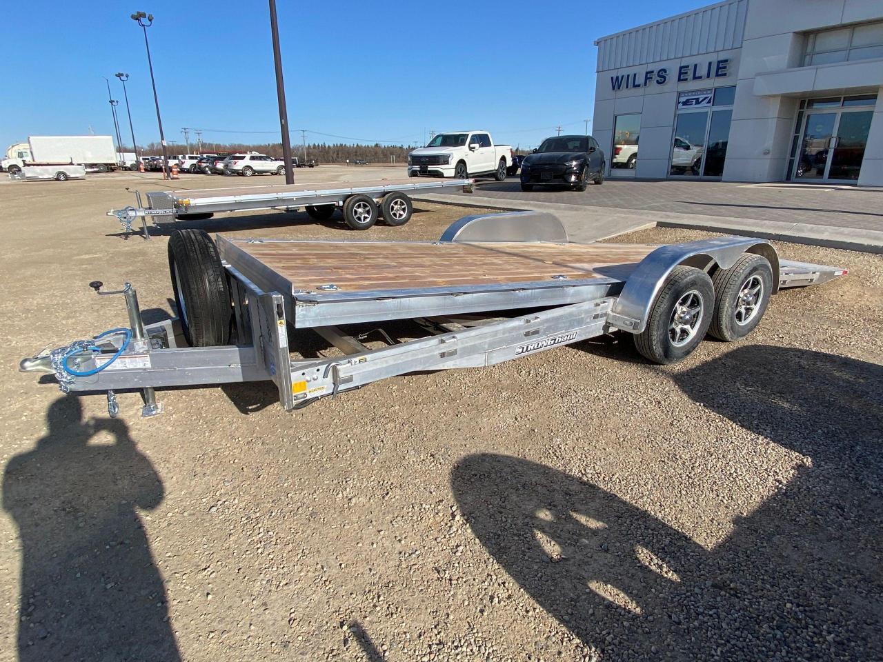 <p><span style=font-family: Segoe UI, sans-serif; background-color: #efefef;>18 + 3 Stronghaul tandem gravity tilt deck car hauler, 19 ride height, 9.5 degree load angle,, 3 knife edge, all aluminum frame, tandem 5200 lb spring axles with brakes, 2 5/16 ball coupler, 15&rdquo; Radial tires, 7 way rv style connector, junction box/break-away kit with charger, LED lighting, enclosed wiring, 5000 lb jack, 2 x 10 douglas fir/larch plank floor, 3/8&rdquo; safety chains, 8 4000 lb D rings, rub rail, spare tire mount, aluminum wheel upgrade with matching spare, A-frame tool box.</span><span style=font-family: Segoe UI, sans-serif;>&nbsp;&nbsp;</span><span style=font-family: Segoe UI, sans-serif; background-color: #efefef;>Stock # HH4970.</span><span style=font-family: Segoe UI, sans-serif;>&nbsp;&nbsp;</span><span style=font-family: Segoe UI, sans-serif; background-color: #efefef;>For more info call Wilf&rsquo;s Elie Ford toll free 877-360-3673. Dealer # 0521.</span></p>
