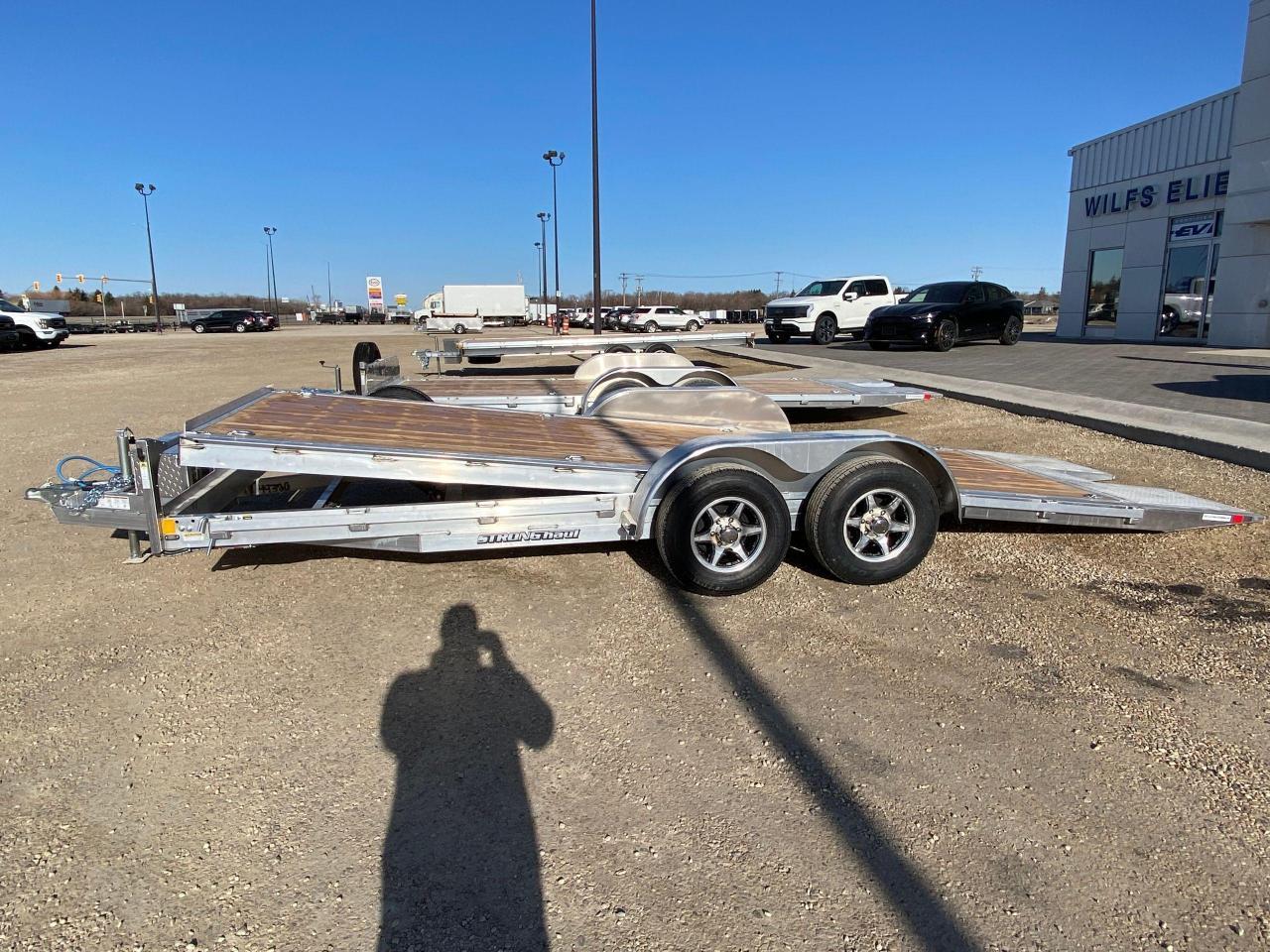 <p class=MsoNormal><span style=font-family: Segoe UI,sans-serif; color: black; mso-color-alt: windowtext; background: #EFEFEF;>18 + 3 Stronghaul tandem gravity tilt deck car hauler, 19 ride height, 9.5 degree load angle,, 3 knife edge, all aluminum frame, tandem 5200 lb spring axles with brakes, 2 5/16 ball coupler, 15&rdquo; Radial tires, 7 way rv style connector, junction box/break-away kit with charger, LED lighting, enclosed wiring, 5000 lb jack, 2 x 10 douglas fir/larch plank floor, 3/8&rdquo; safety chains, 8 4000 lb D rings, rub rail, spare tire mount, aluminum wheel upgrade with matching spare, A-frame tool box.<span style=mso-spacerun: yes;>&nbsp; </span>Stock # HH4969.<span style=mso-spacerun: yes;>&nbsp; </span>For more info call Wilf&rsquo;s Elie Ford toll free 877-360-3673. Dealer # 0521.</span></p>