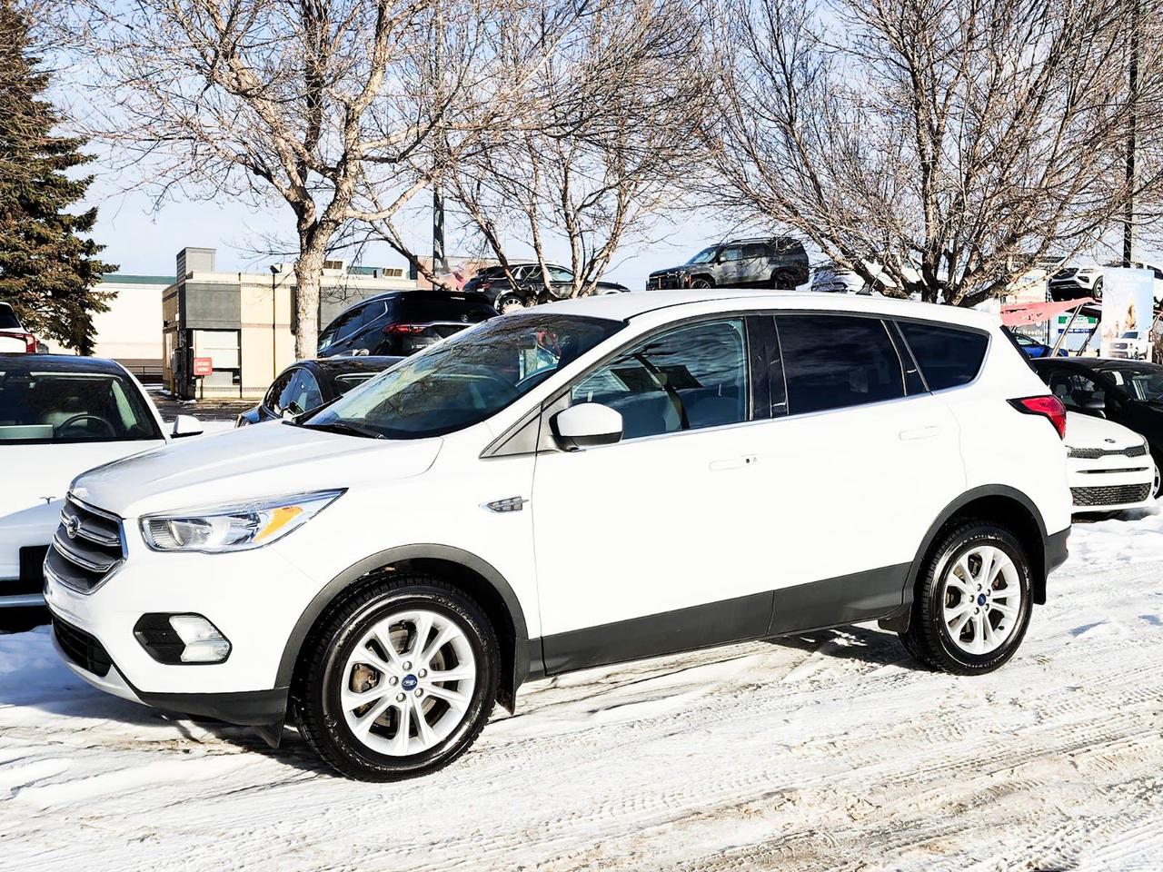 Recent Arrival! Odometer is 58532 kilometers below market average! White 2019 Ford Escape SE 4WD 6-Speed Automatic 1.5L EcoBoost4WD, 3.51 Axle Ratio, 4-Wheel Disc Brakes, 6 Speakers, ABS brakes, Air Conditioning, Alloy wheels, AM/FM radio: SiriusXM, AppLink/Apple CarPlay and Android Auto, Automatic temperature control, Block heater, Brake assist, Bumpers: body-colour, Compass, Delay-off headlights, Driver door bin, Driver vanity mirror, Dual front impact airbags, Dual front side impact airbags, Electronic Stability Control, Emergency communication system: SYNC 3 911 Assist, Exterior Parking Camera Rear, Four wheel independent suspension, Front anti-roll bar, Front Bucket Seats, Front dual zone A/C, Front fog lights, Front reading lights, Fully automatic headlights, Heated door mirrors, Heated front seats, Heated Unique Cloth Front Bucket Seats, Illuminated entry, Knee airbag, Low tire pressure warning, Occupant sensing airbag, Outside temperature display, Overhead airbag, Overhead console, Panic alarm, Passenger door bin, Passenger vanity mirror, Power door mirrors, Power driver seat, Power steering, Power windows, Radio data system, Radio: AM/FM/MP3 Capable, Rear anti-roll bar, Rear window defroster, Rear window wiper, Remote keyless entry, Security system, Speed control, Speed-sensing steering, Split folding rear seat, Steering wheel mounted audio controls, SYNC 3 Communications & Entertainment System, Tachometer, Telescoping steering wheel, Tilt steering wheel, Traction control, Trip computer, Variably intermittent wipers, Wheels: 17 Sparkle Silver-Painted Aluminum.IN HOUSE FINANCING, IN HOUSE LEASING AVAILABLE O.A.C.If you are interested and need more information call or message our sales team, we will be glad to help you now!!Our knowledgeable sales staff will help assist you with every step. To book a test drive or receive further information give us a call at (780)-465-3535 or email us: kiahmed@gokia.caAt Go Kia, were happy to help! Proudly serving Edmonton and all of Alberta including St. Albert, Wetaskiwin, Fort McMurray, Grande Prairie, Drayton Valley, Nisku, Leduc, Rimby, Hinton, St. Paul, Lloydminster, Edson, and all of Western Canada!An AMVIC Licensed Business. Value Priced vehicles are aggressively priced and may require some additional mechanical or cosmetic repairs, all disclosed on a Vehicle Assessment Report!This vehicle may be leased or financed by anyone*, however, due to the recent increase in fraudulent vehicle purchase activity, Go Kia reserves the right to decline a transaction on suspicion of non-retail intentions including but not limited to wholesaling or exporting.*on approved credit, see dealer for details